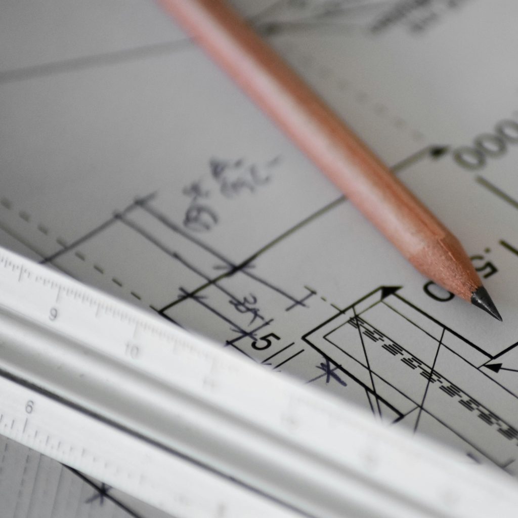 Papier kreślarski z ołówkiem, na papierze narysowany projekt architektoniczny.