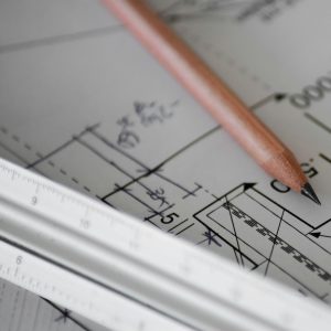 Papier kreślarski z ołówkiem, na papierze narysowany projekt architektoniczny.